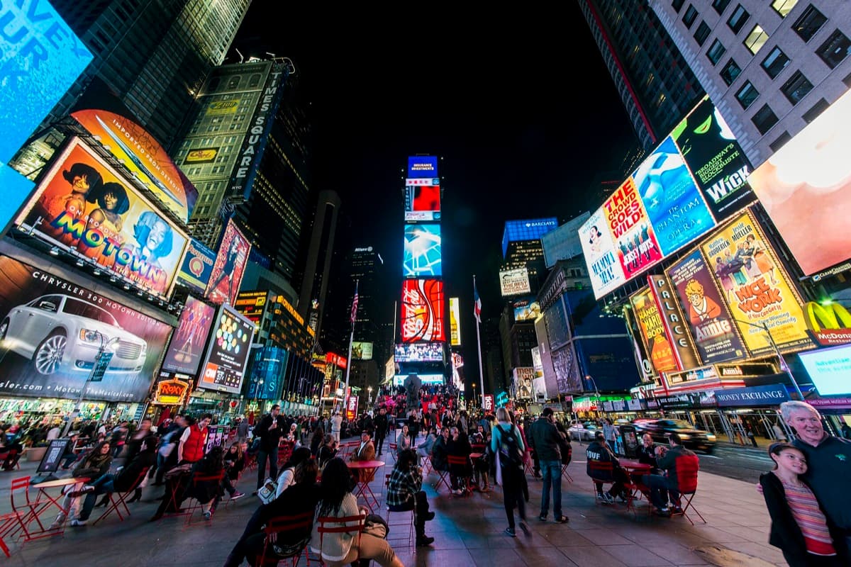 Times Square at night with lit screens and crowds