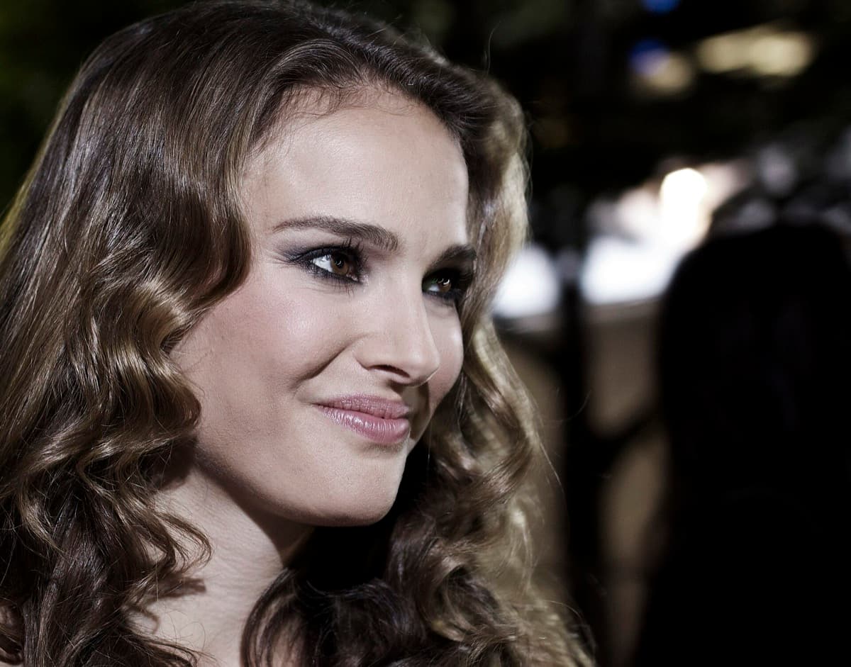 A woman with dark hair smiling at a premiere