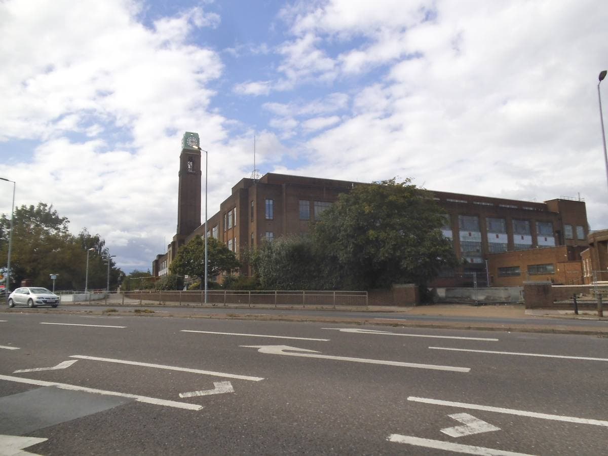 A long brick Art Deco factory front with a tall clock tower