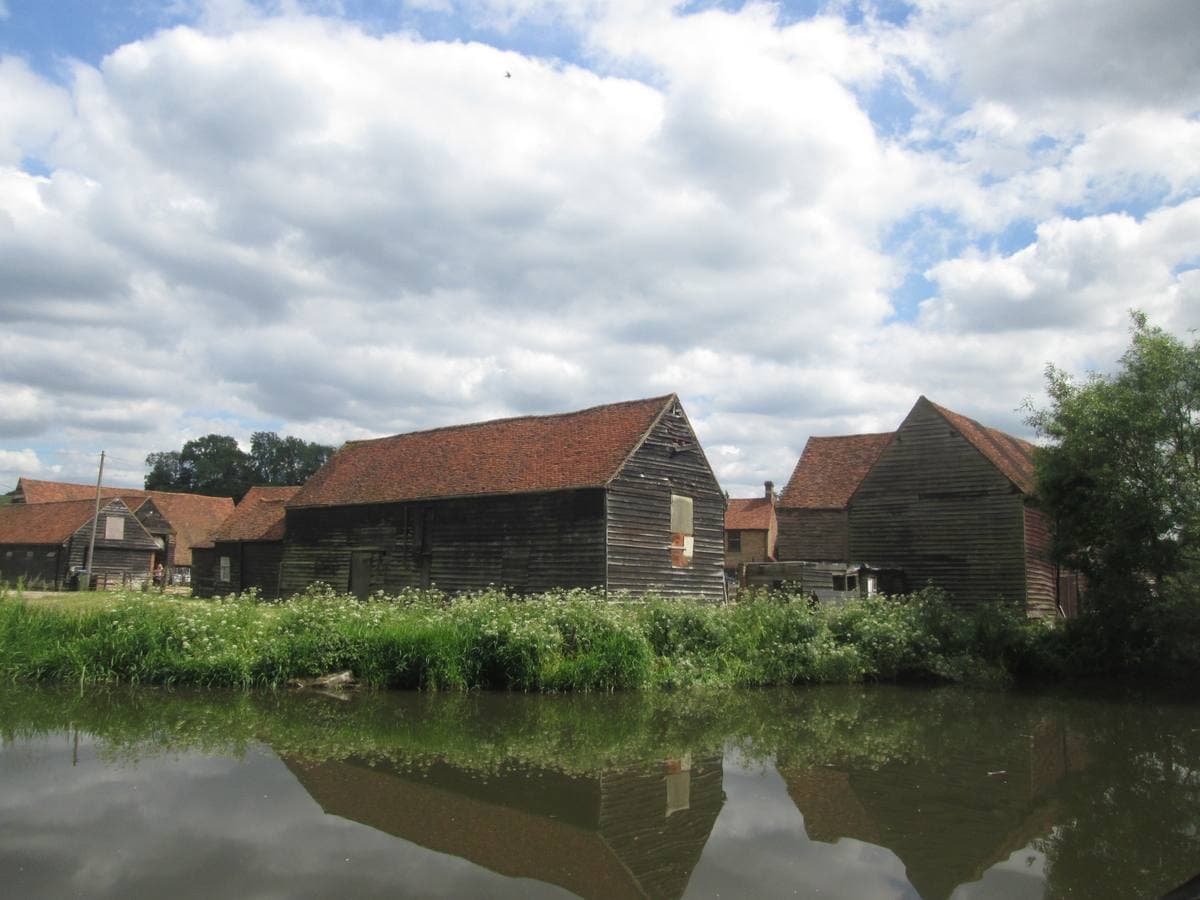 Old timber farm buildings behind a fence
