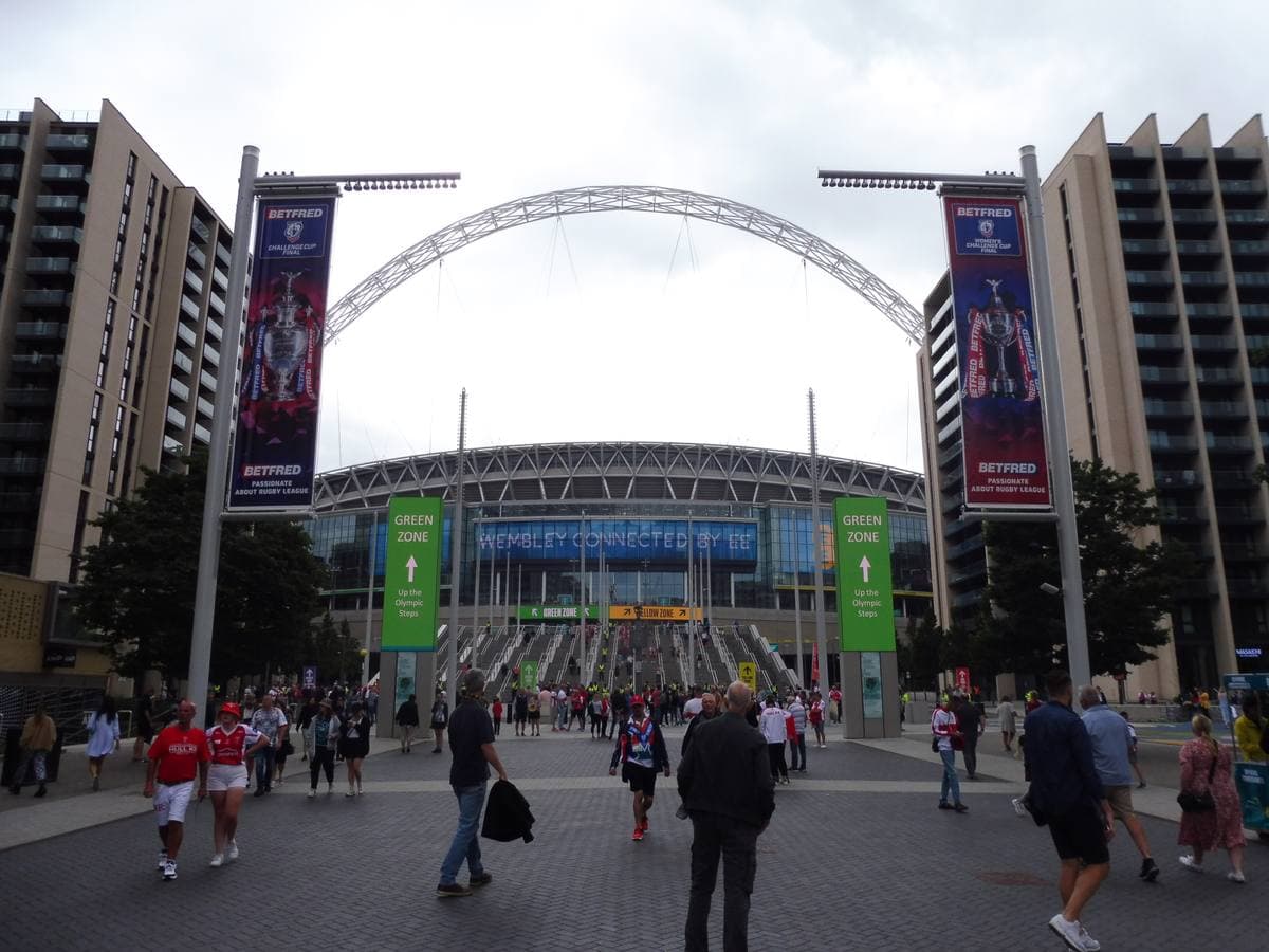 Crowds walking up Olympic Way towards Wembley Stadium and its arch