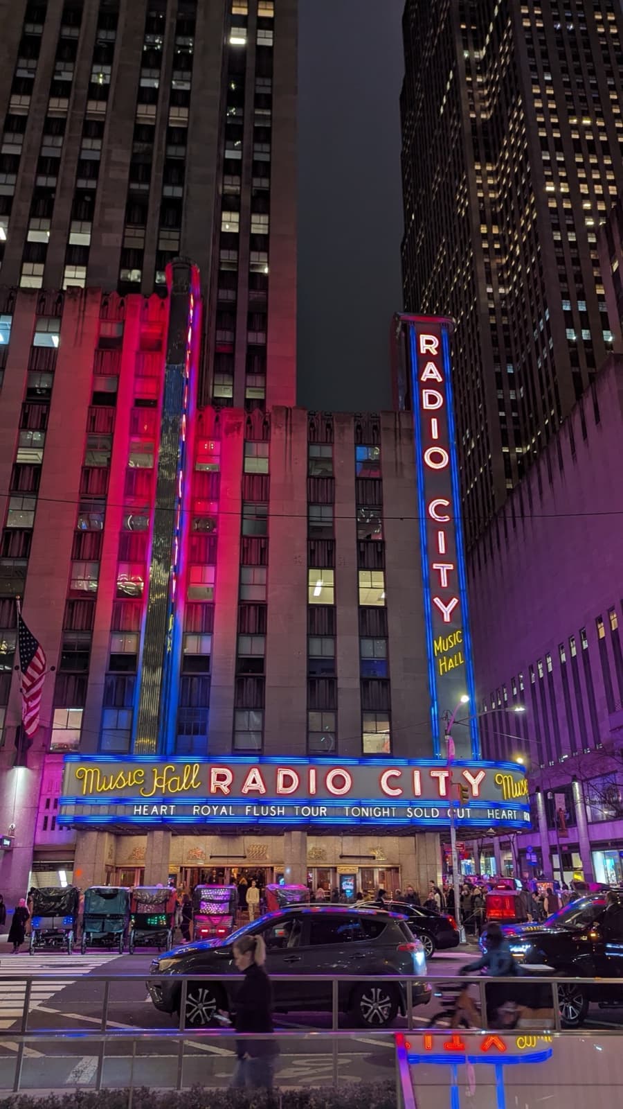 The neon Radio City marquee and vertical sign glowing red and blue at night