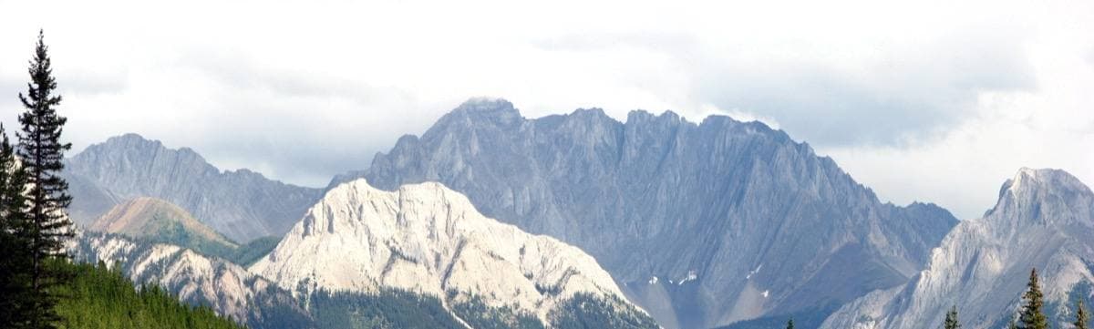 A wide, flat-topped rock fortress of a mountain above forest