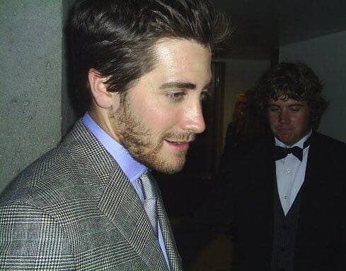 Jake Gyllenhaal smiling at a film opening, dark hair, open-necked shirt
