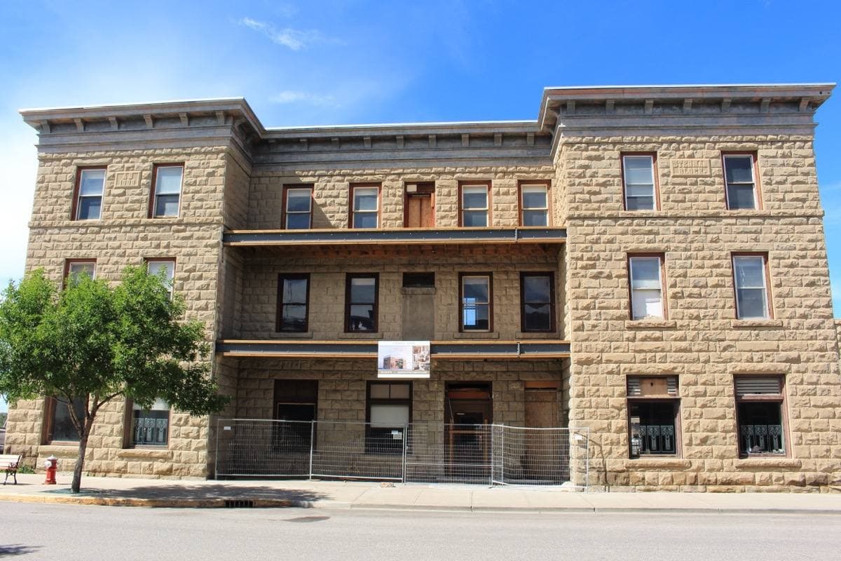 A sandstone corner hotel with a metal cornice on a small-town main street