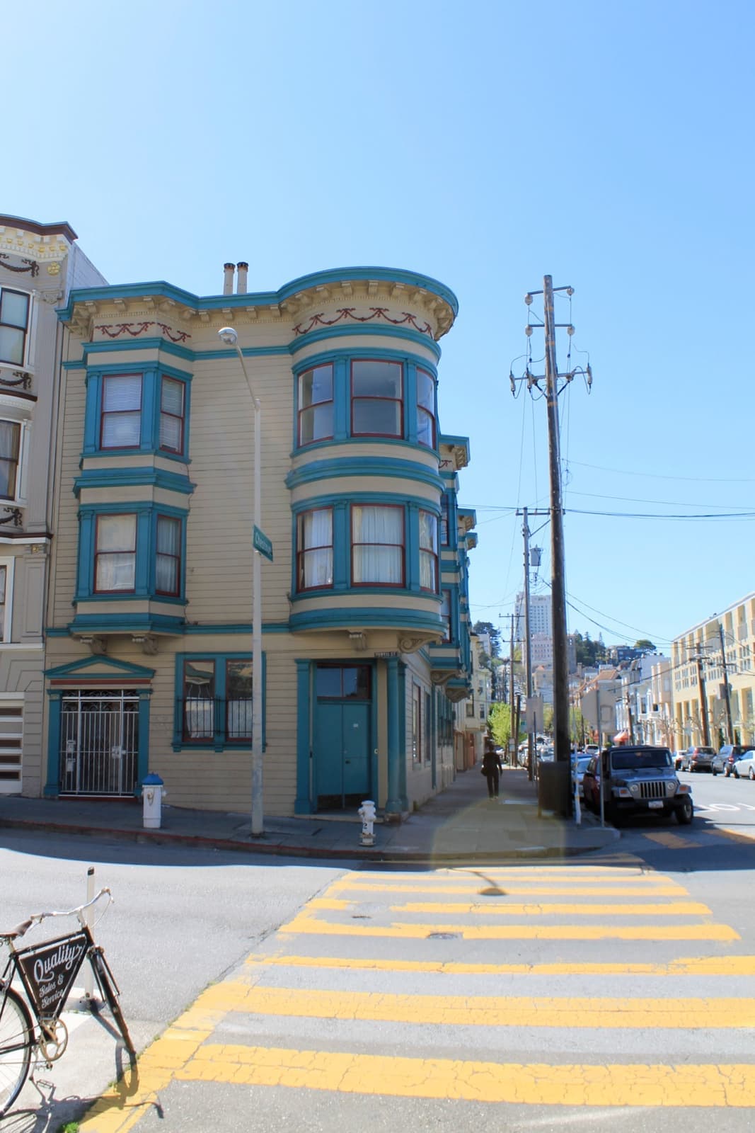A steep residential street rising between painted houses