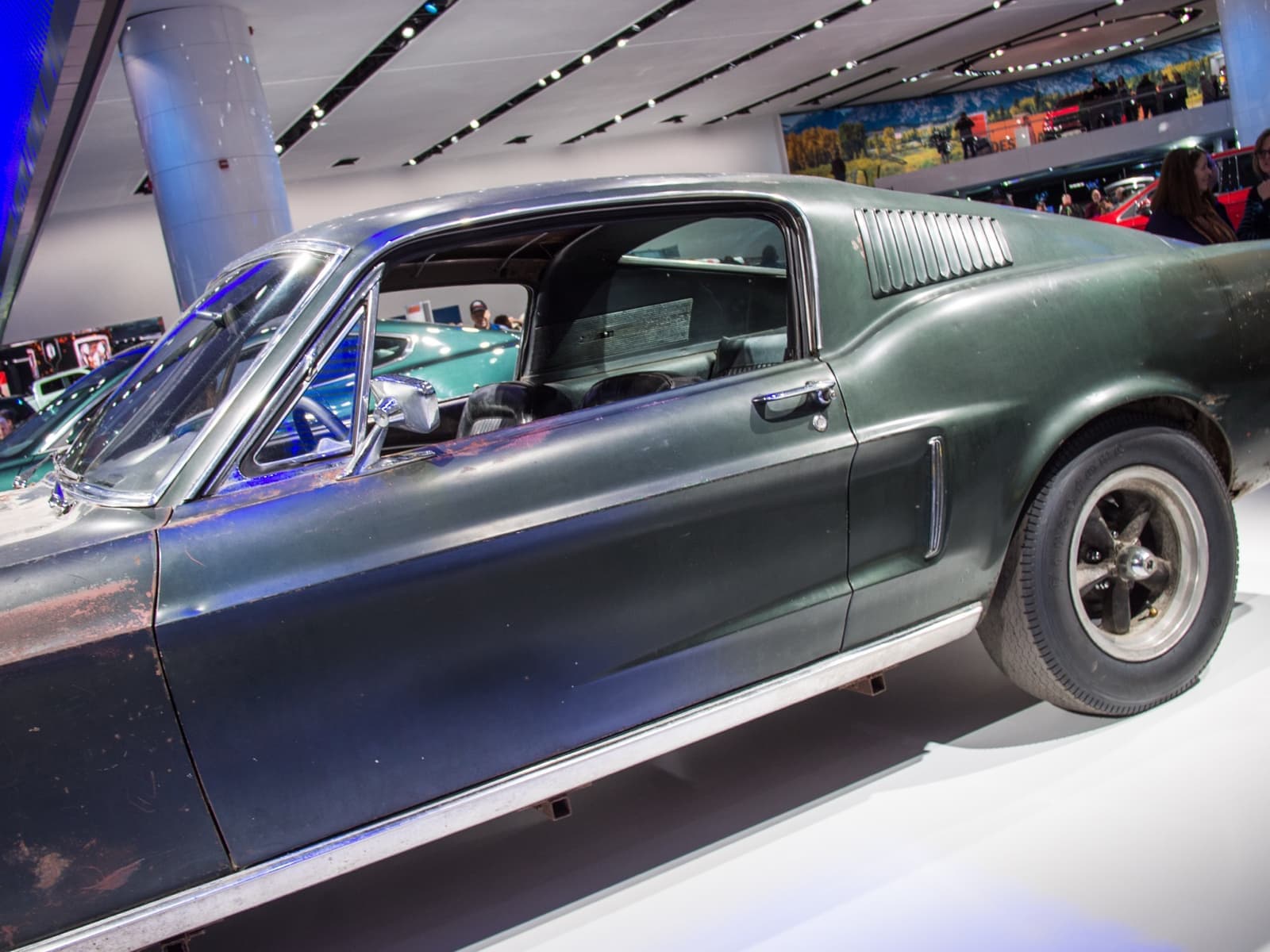 The front of a dark green 1968 Mustang fastback with a black grille and no badge
