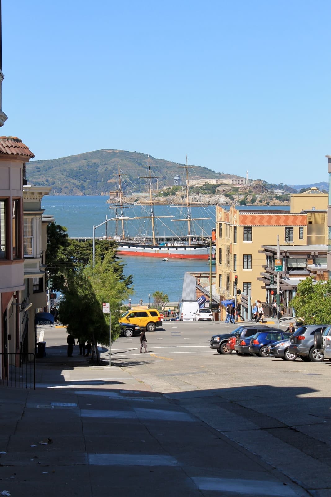 A street dropping steeply towards the bay with an island in the distance