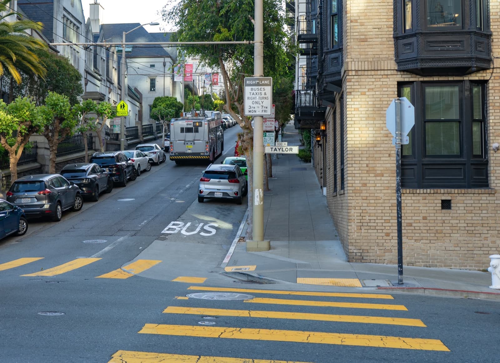 A steep street of apartment buildings crossing at a hilltop