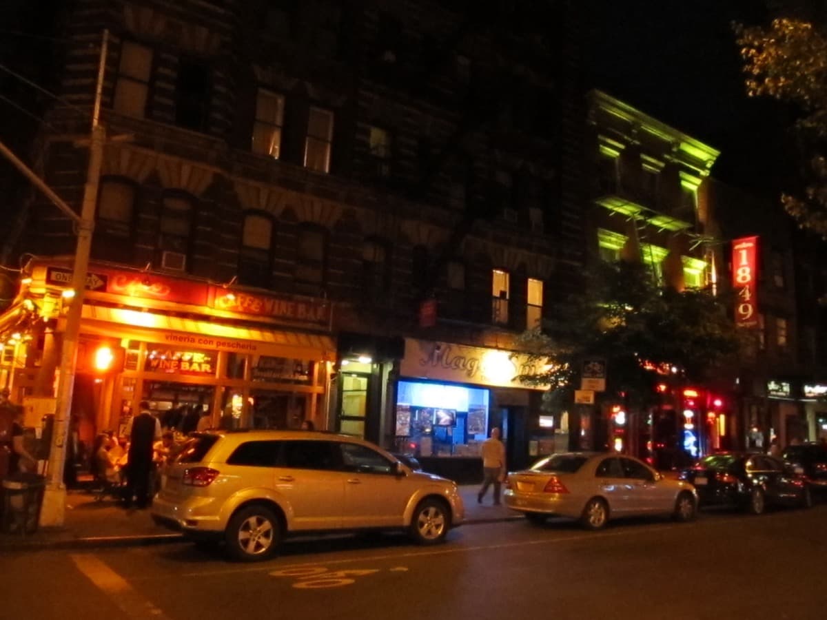 A village street of low brick buildings with awnings and pedestrians