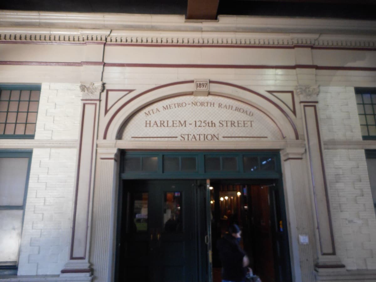 A station entrance beneath a railway viaduct on a city street