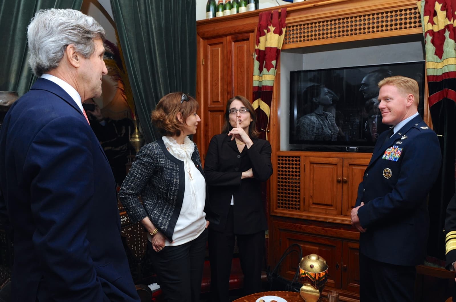 John Kerry and others stand before a screen showing Casablanca inside Rick’s Café