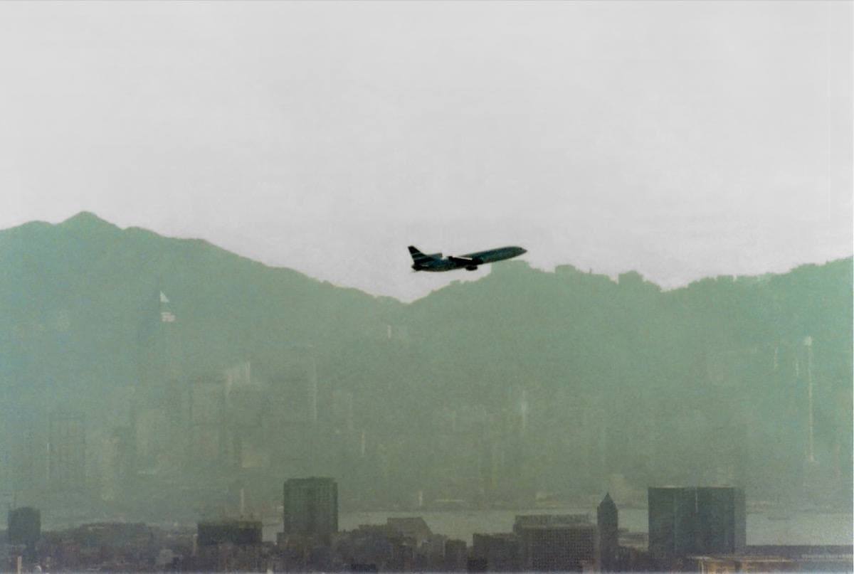 View from a plane window over Kowloon Bay and the Kai Tak runway, the island beyond