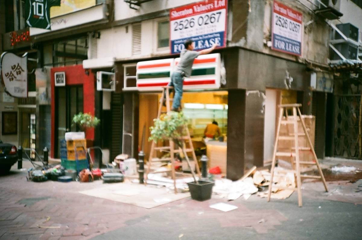 A small 7-Eleven shopfront on a sloping street in Lan Kwai Fong