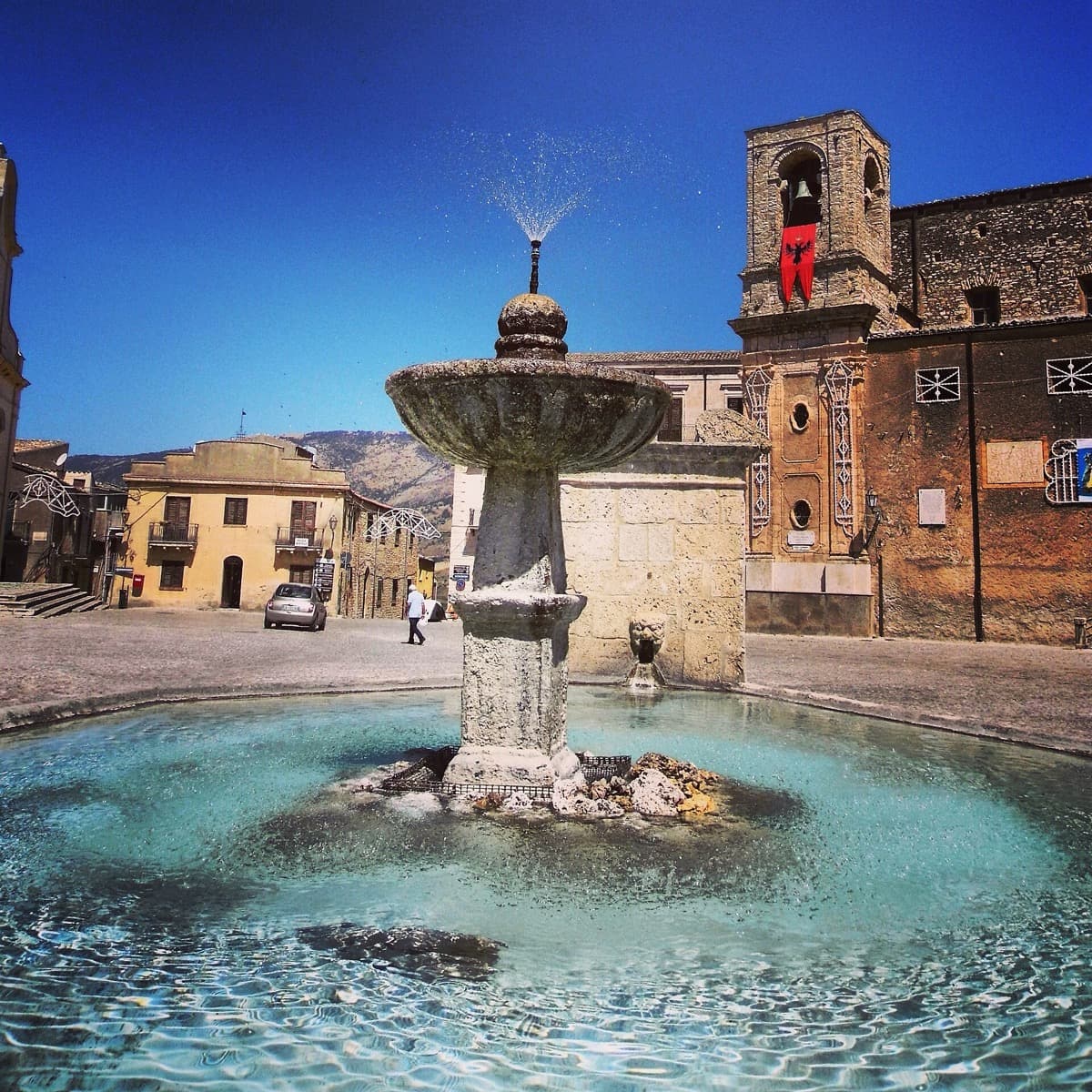 An octagonal stone fountain in a town square