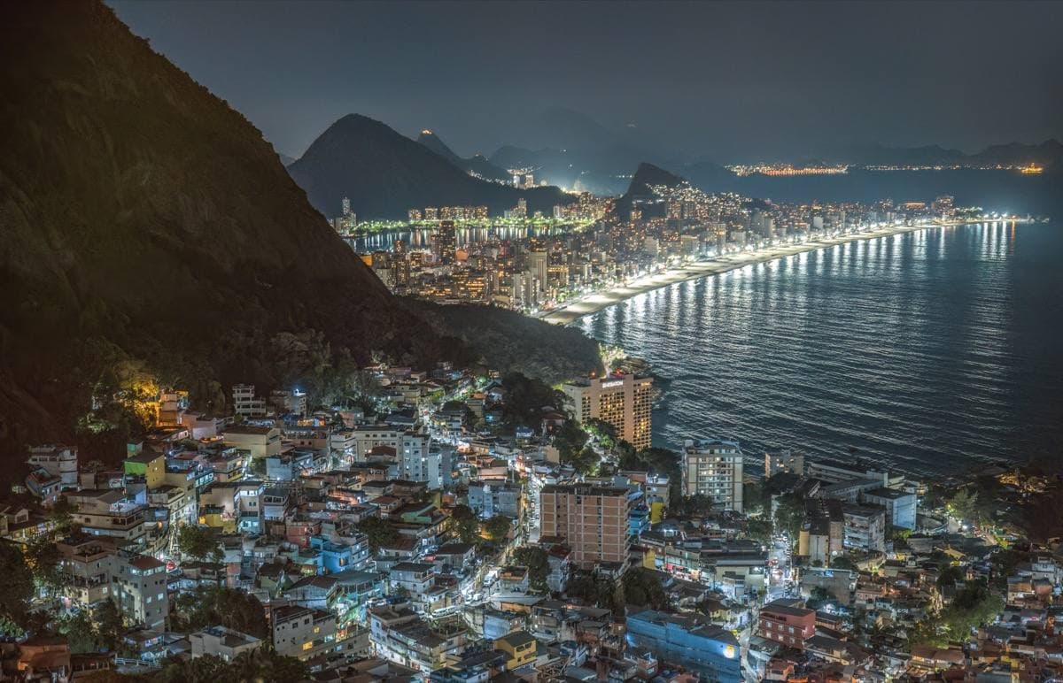 Colourful houses of Vidigal stacked on a steep green hillside