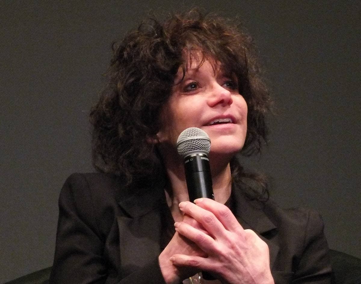 Amy Heckerling with curly dark hair speaking into a microphone