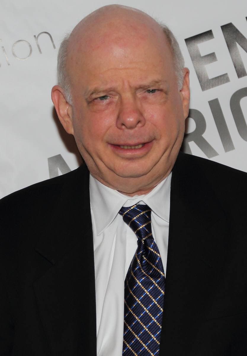 Wallace Shawn smiling, bald, in glasses