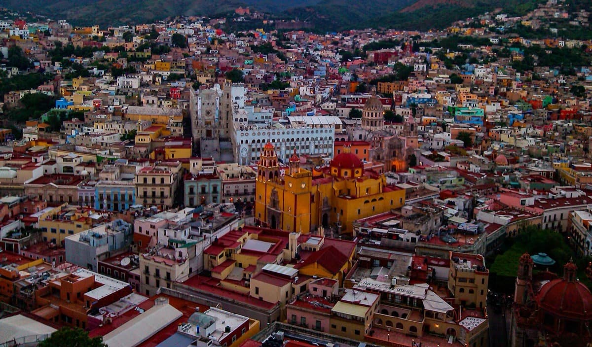 A hillside city of colourful houses glowing at sunset