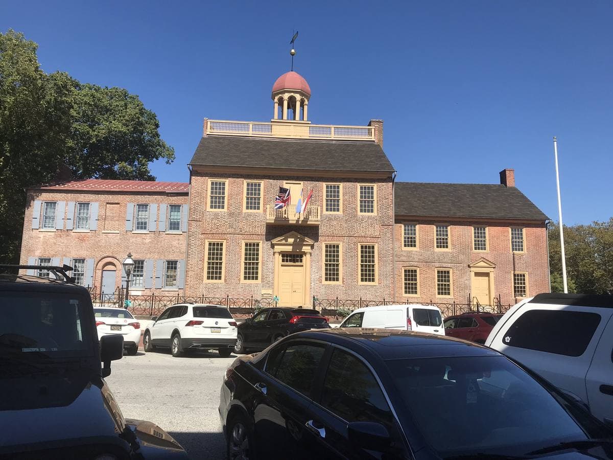 A brick colonial courthouse with a white cupola and flanking wings