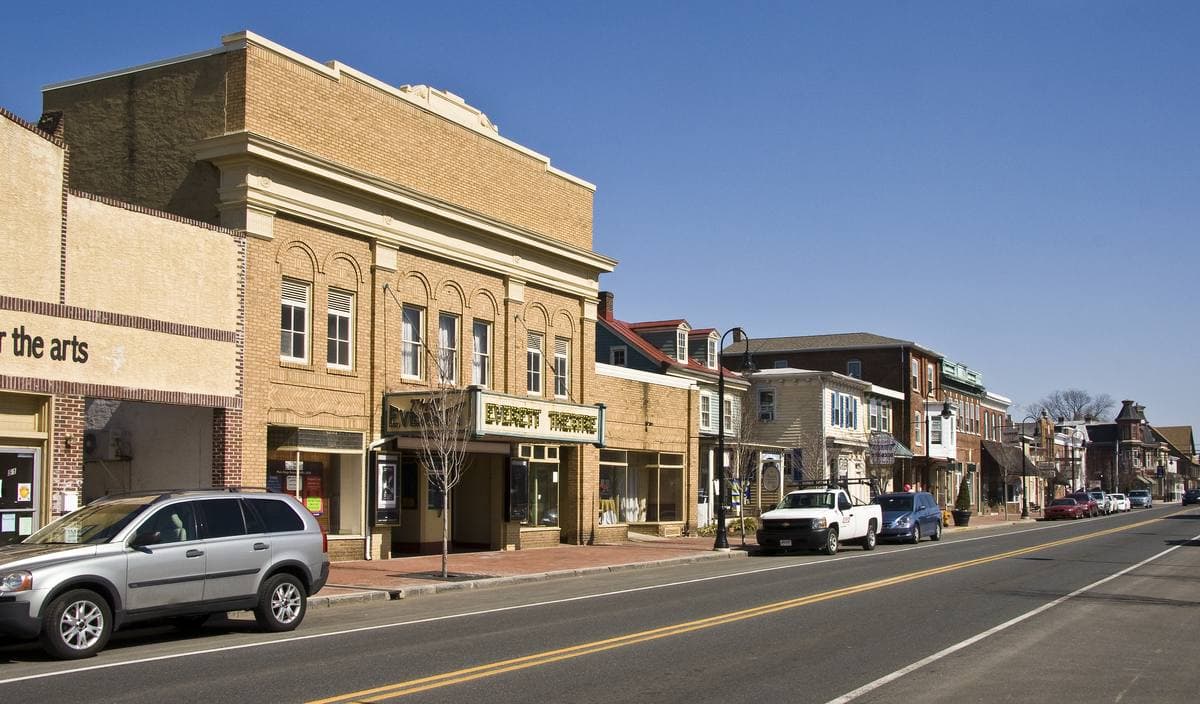 A small-town main street with the Everett Theatre's marquee among brick and stone shopfronts