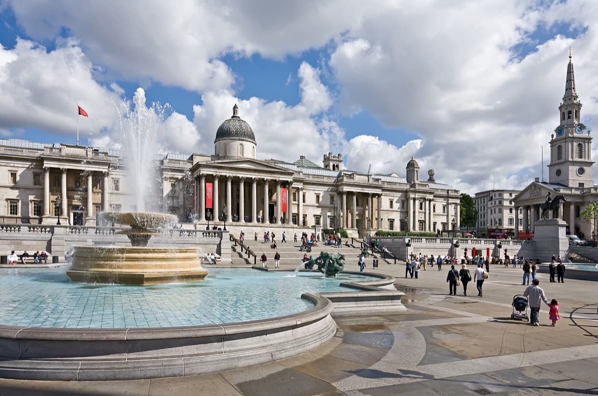 A wide London square with a tall column, fountains and a portico church