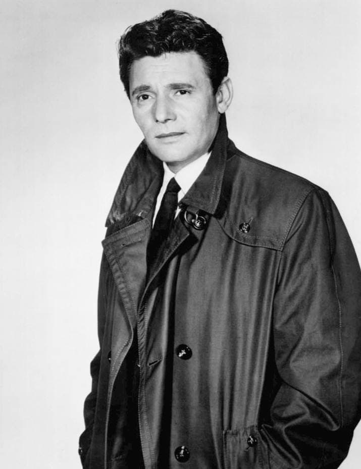 Harry Guardino in a dark raincoat and tie, standing