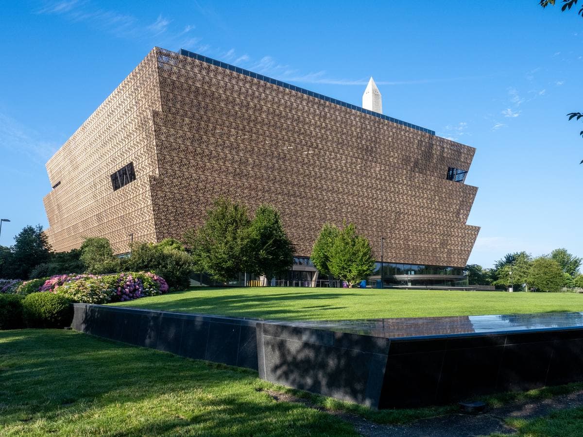 The bronze-latticed tiers of the National Museum of African American History and Culture under a blue sky