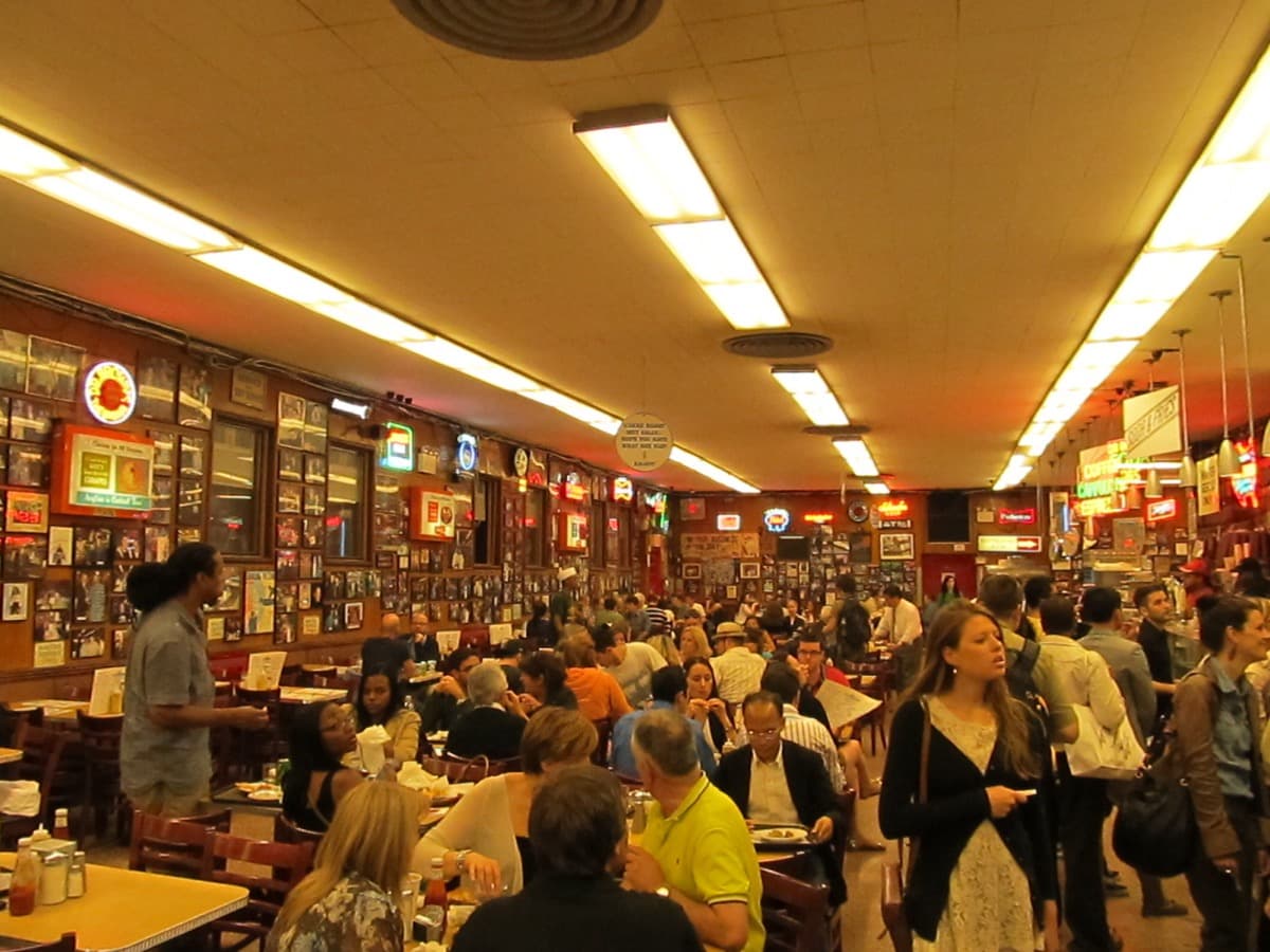 The front of Katz's Delicatessen with its neon signs on a Manhattan street corner