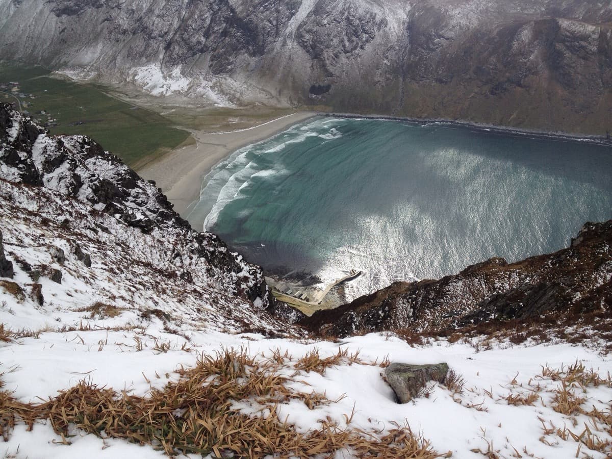 A pale sandy bay between dark rocky headlands under a winter sky