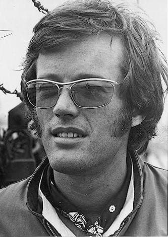 Peter Fonda in tinted wire-framed glasses and a neckerchief, hair windblown