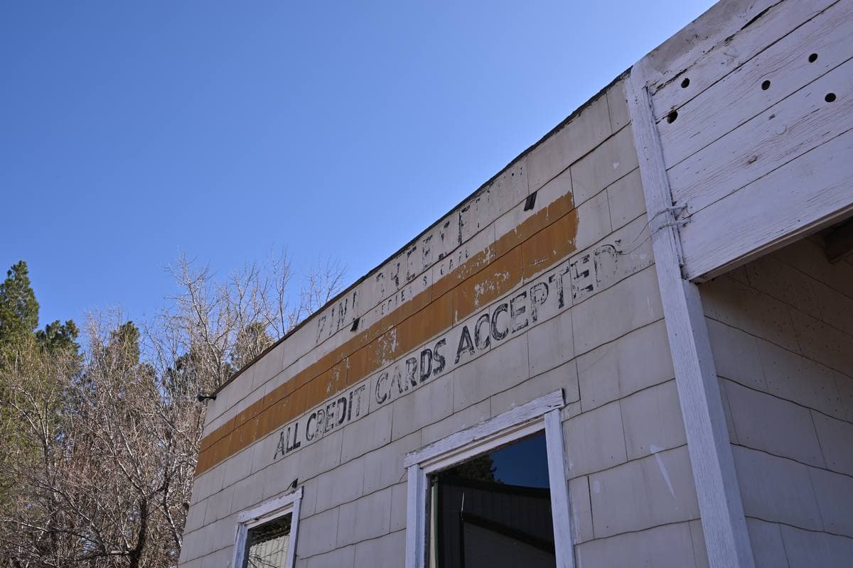 Close view of faded painted lettering on white clapboard