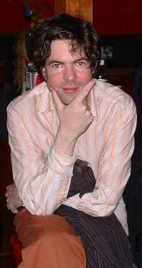 Jon Brion in a striped shirt, chin on his hand