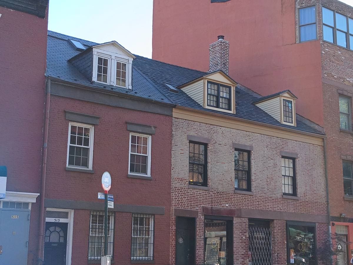 Two old brick houses with dormer windows on a city street