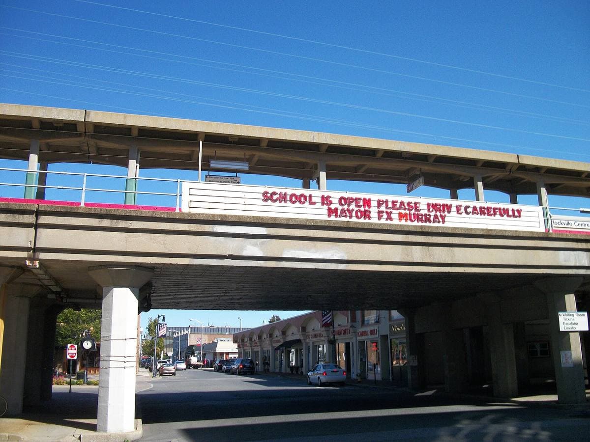 An elevated railway station on concrete piers over a street