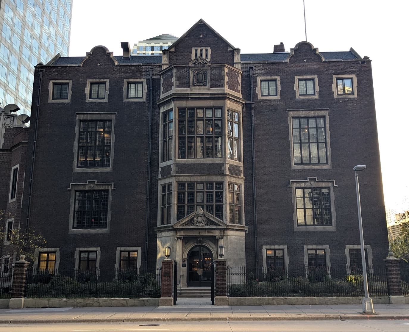 A dark stone Tudor-style clubhouse with tall bay windows