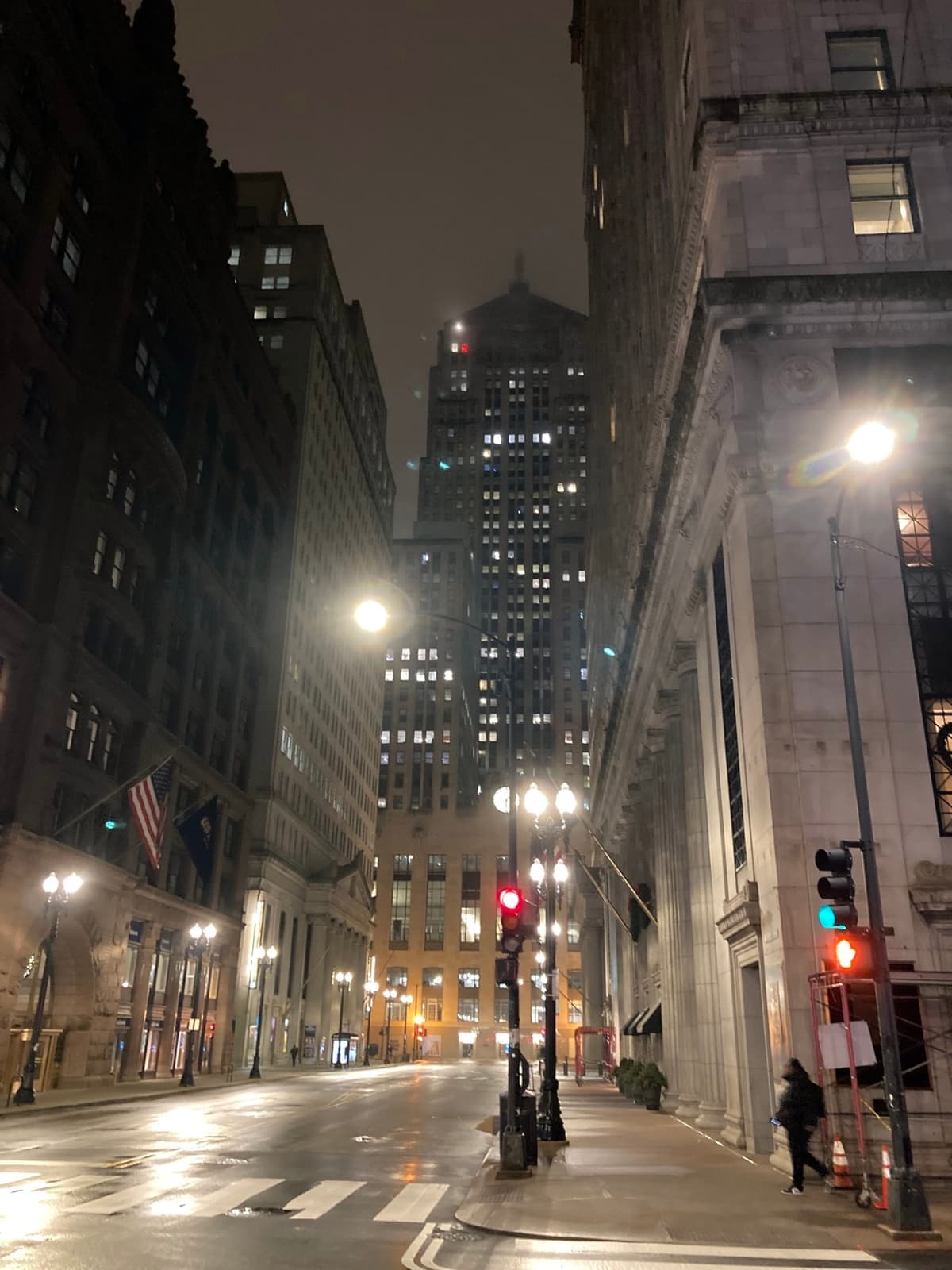 The Art Deco Board of Trade tower lit at dusk at the end of a canyon of office buildings