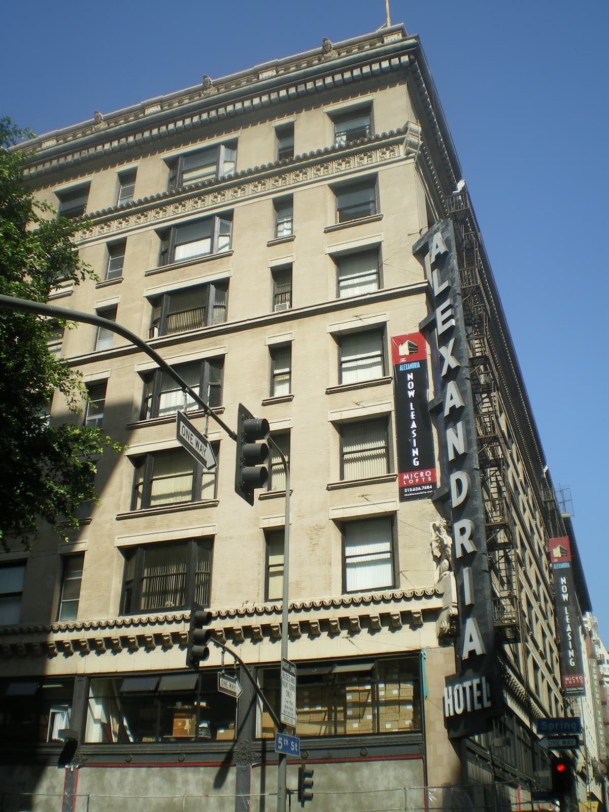A pale stone corner hotel with a vertical Alexandria sign