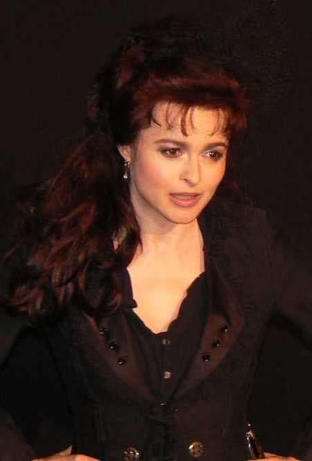 Helena Bonham Carter with long dark red hair, in a black jacket