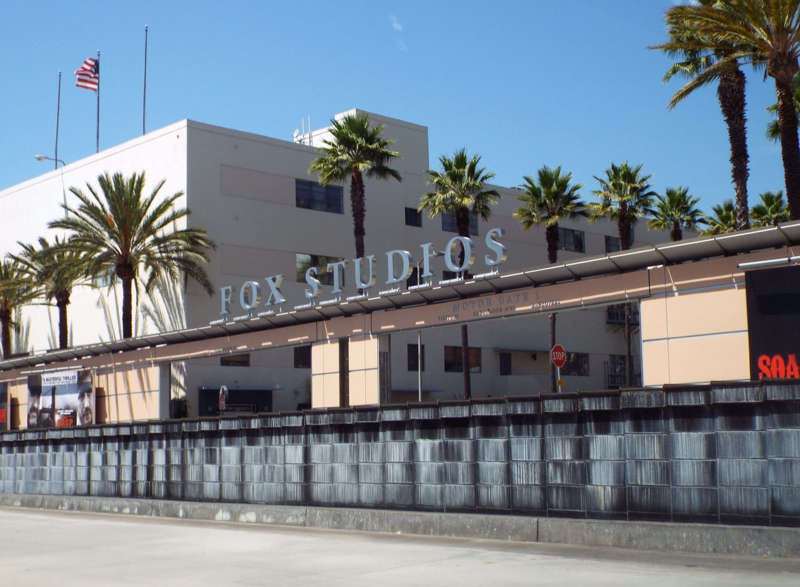 A low studio building with a Fox Studios sign behind palms