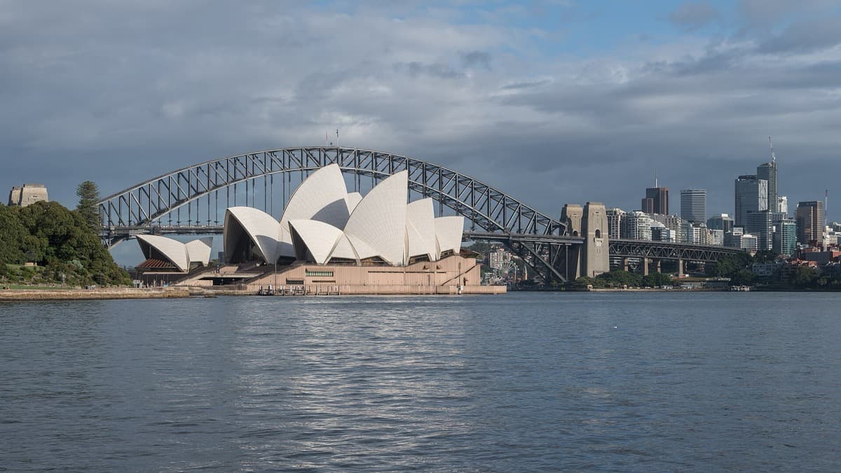The sails of the Opera House beside the arch of the Harbour Bridge across the water