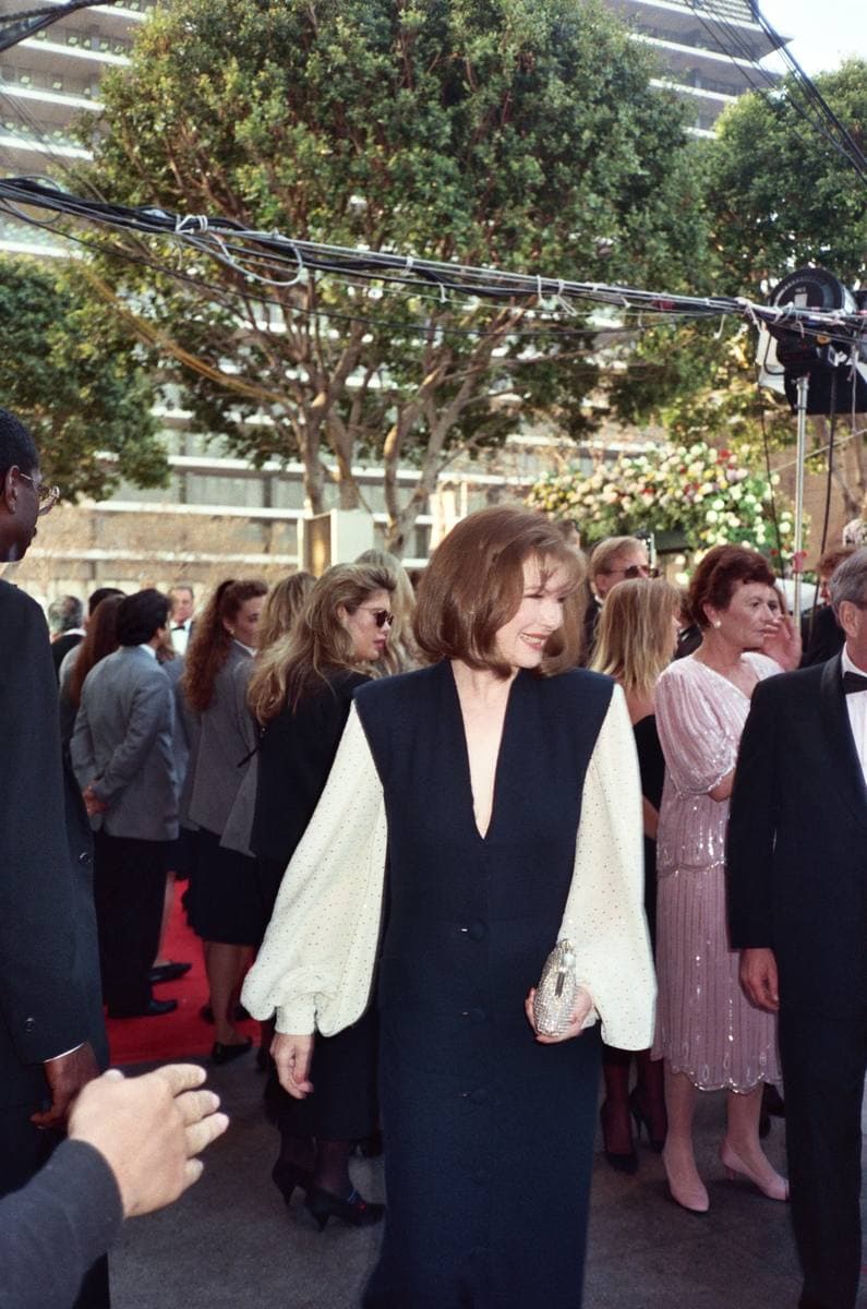 Dianne Wiest in a dark dress with white sleeves, in a crowd on the red carpet
