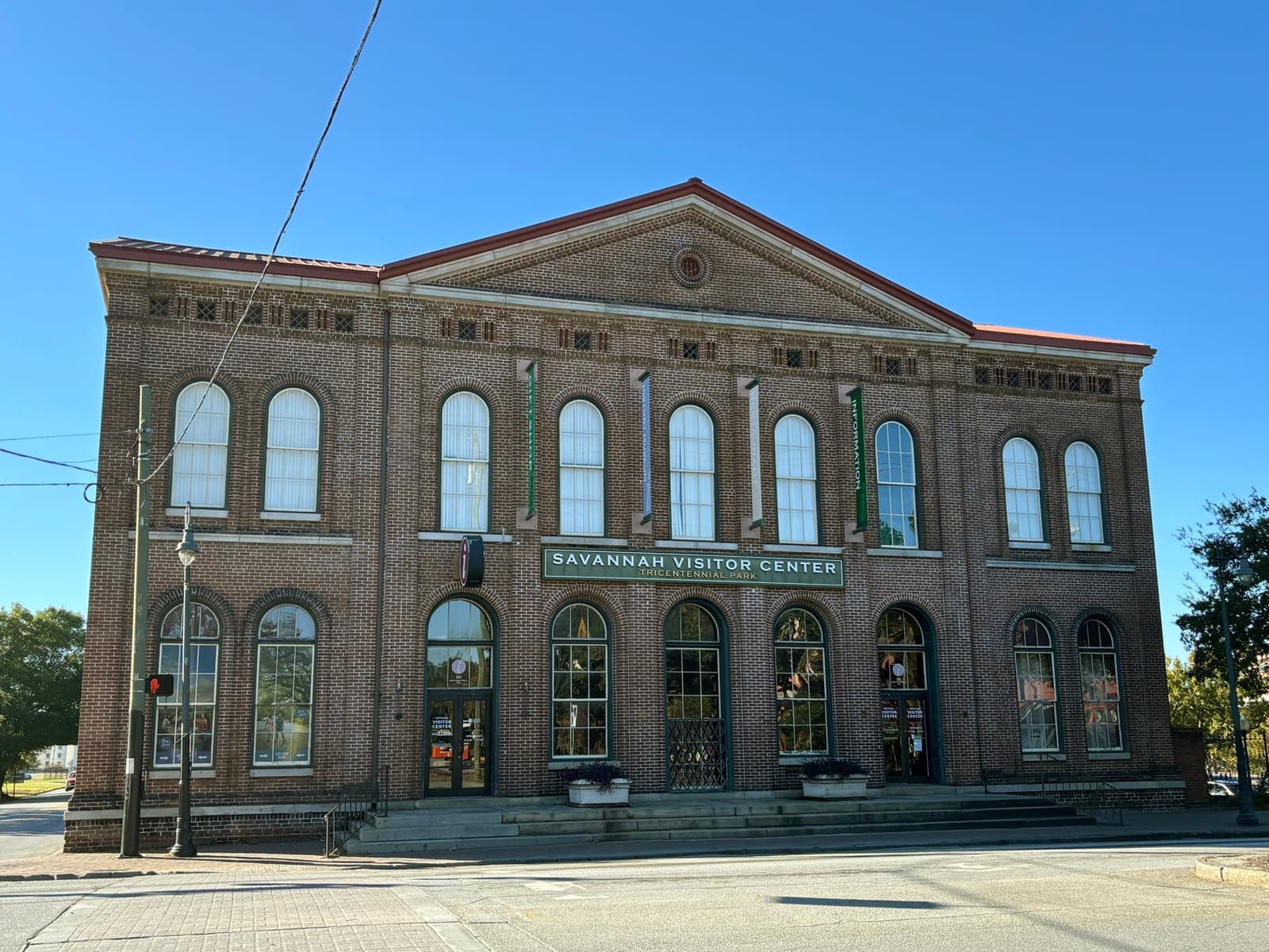 A brick railway station with tall arched windows and a sign reading Savannah Visitor Center