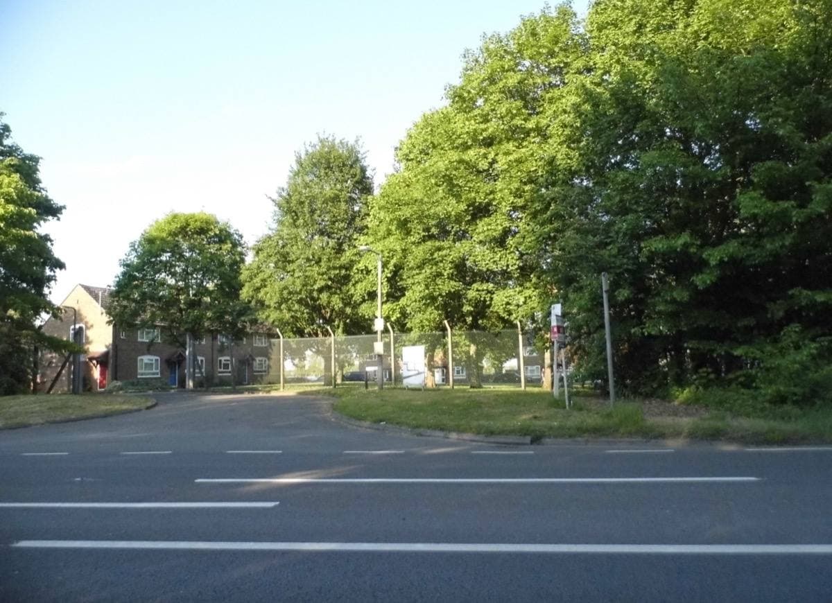 A road and a closed gate between trees at Bassingbourn Barracks