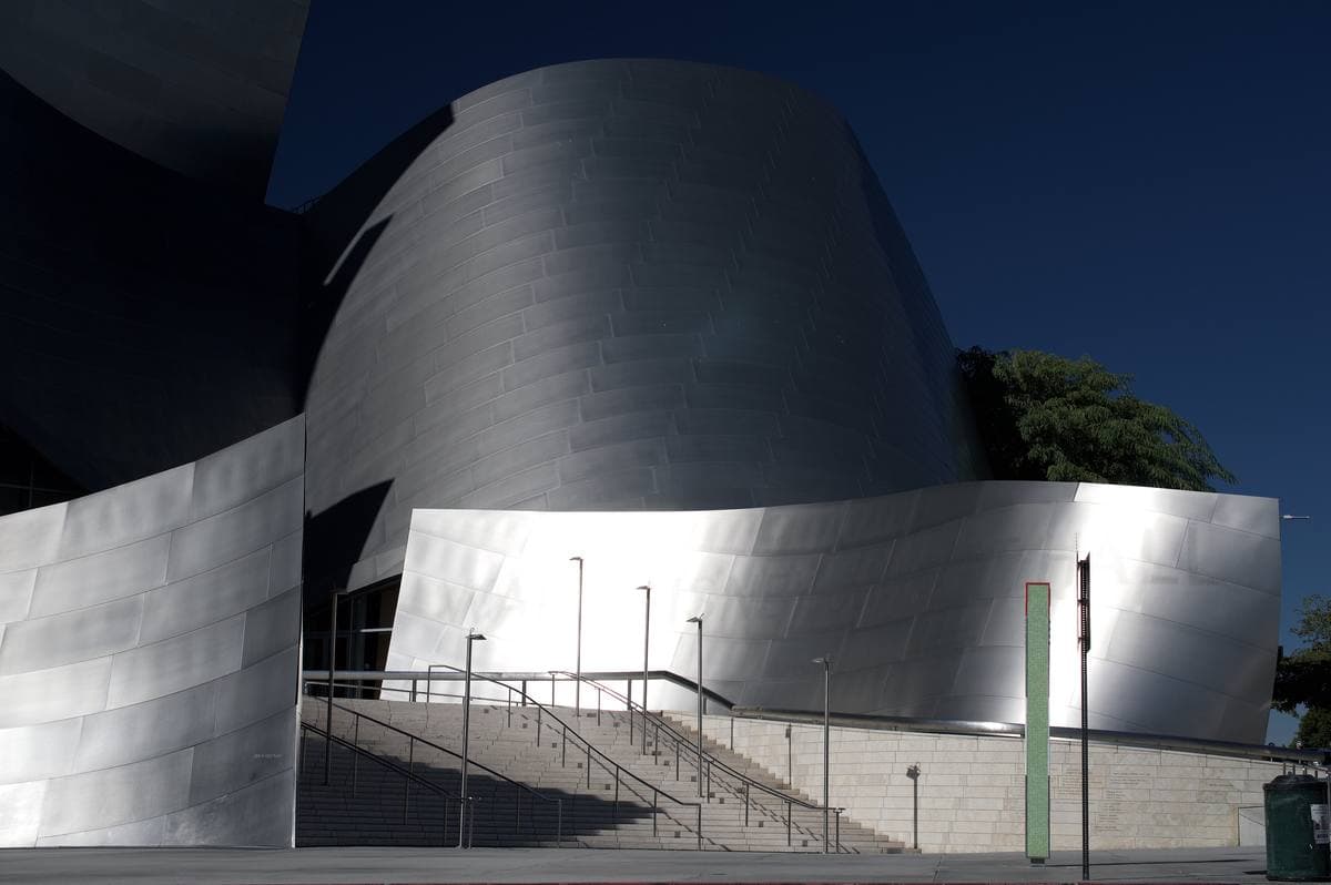 The curved stainless-steel walls of Walt Disney Concert Hall against a dark sky