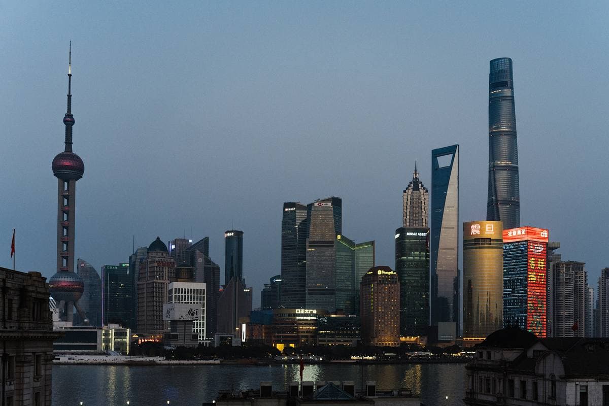 The Pudong skyline at dusk, with the Oriental Pearl Tower and tall towers across the river