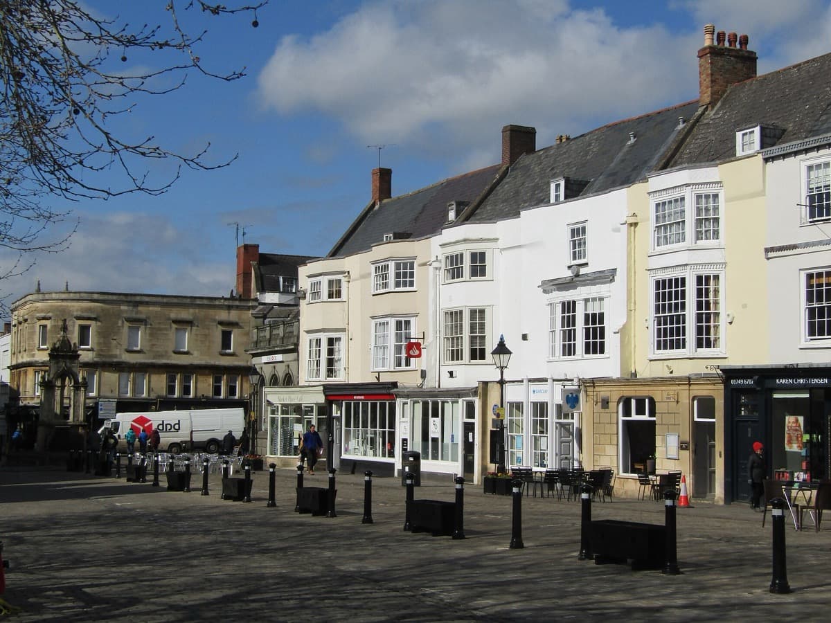 A paved market square with old stone and rendered buildings around it
