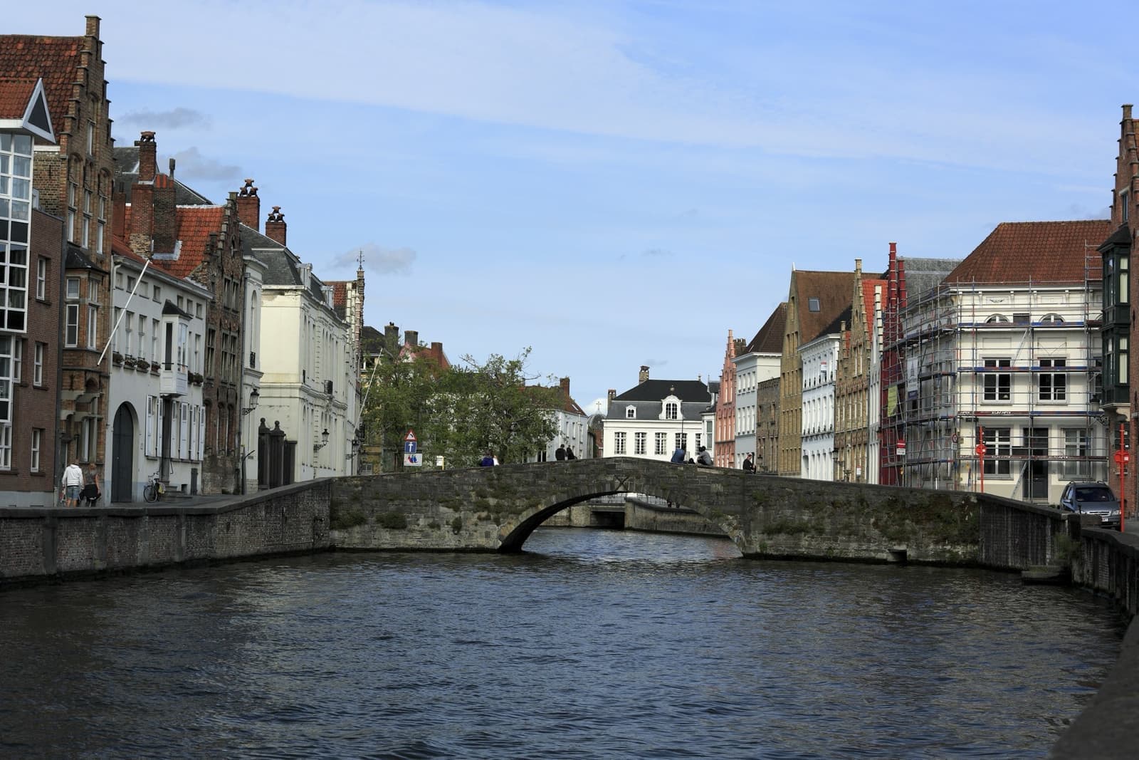 A low stone bridge across a wide canal lined with gabled houses