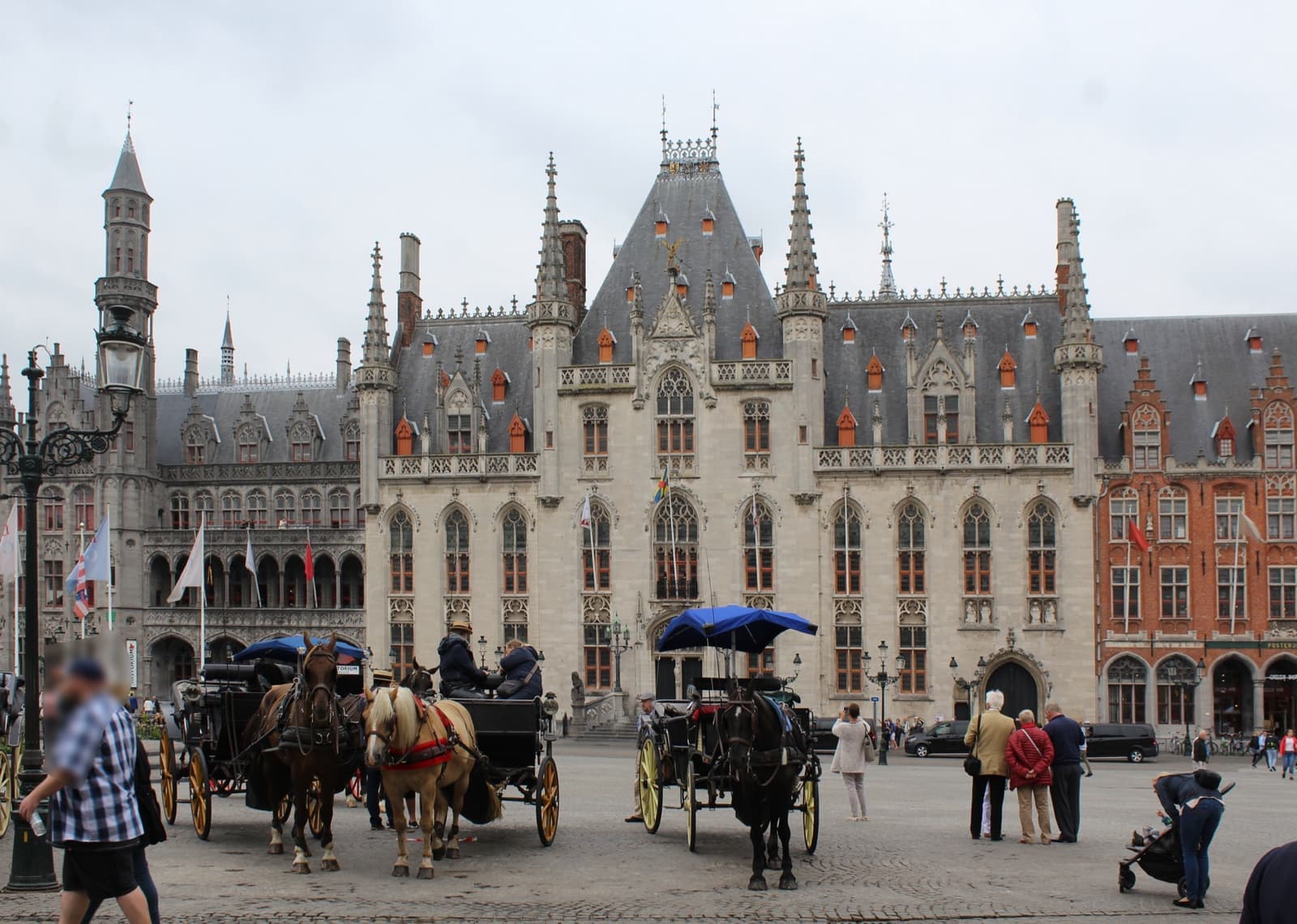 Horse-drawn carriages in front of the neo-Gothic Provincial Court on the Markt