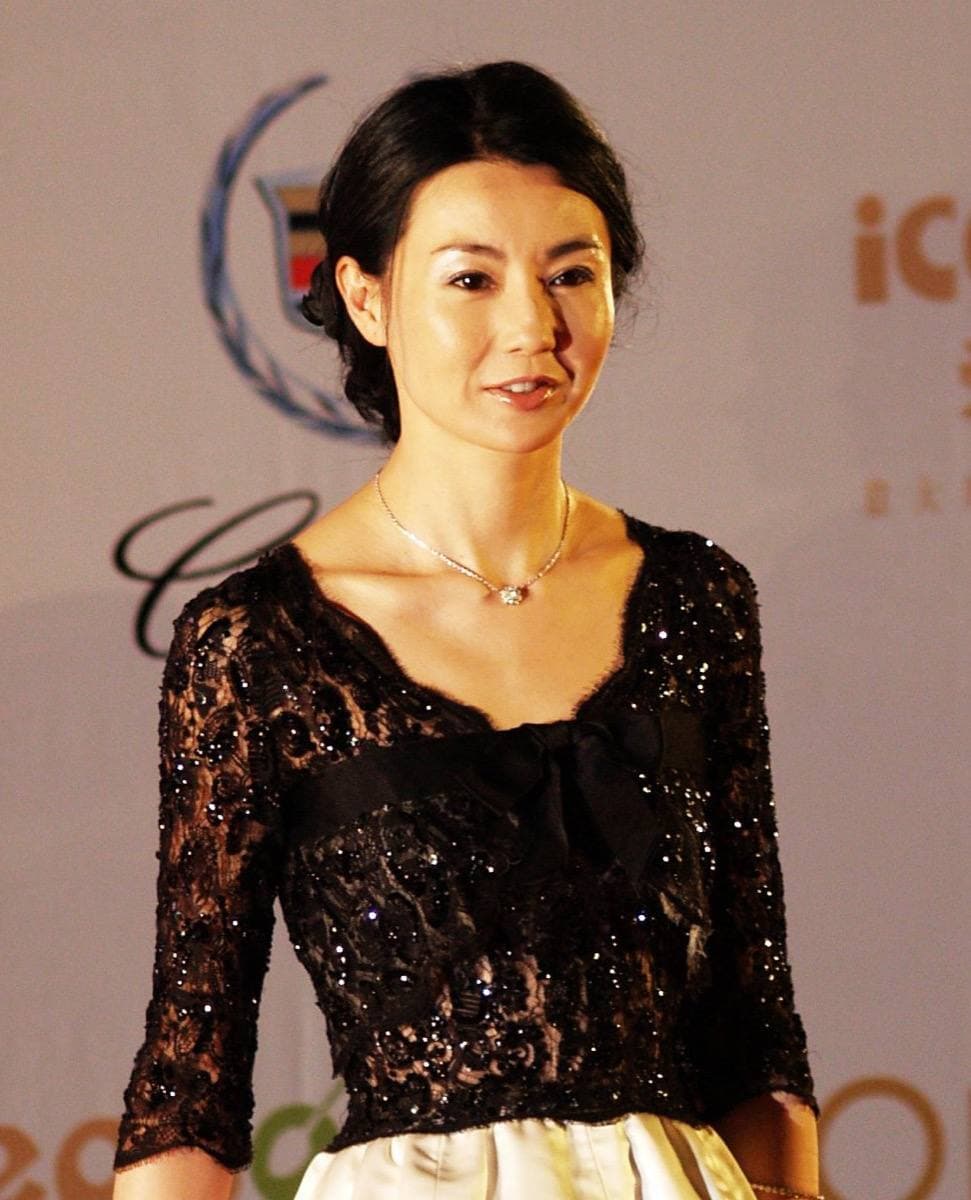 Maggie Cheung in a black lace dress, her hair pinned up, glancing to one side